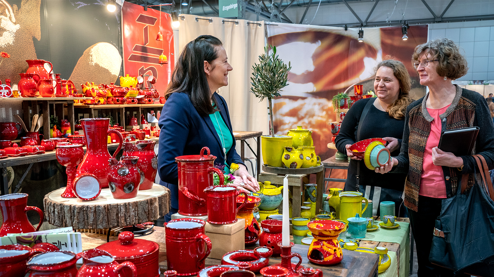 Besucher unterhalten sich mit Keramik-Ausstellerin bei der CADEAUX Leipzig.