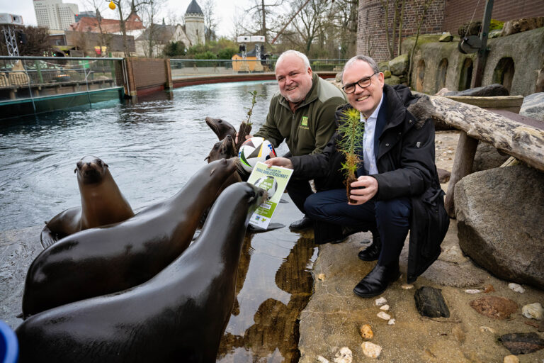 Martin Buhl-Wagner, Geschäftsführer der Leipziger Messe (re) und Prof. Jörg Junhold, Direktor des Zoo Leipzig, zusammen mit Seelöwen bei der Übergabe der Spendenurkunde zur Aktion "Waldmeisterschaft"