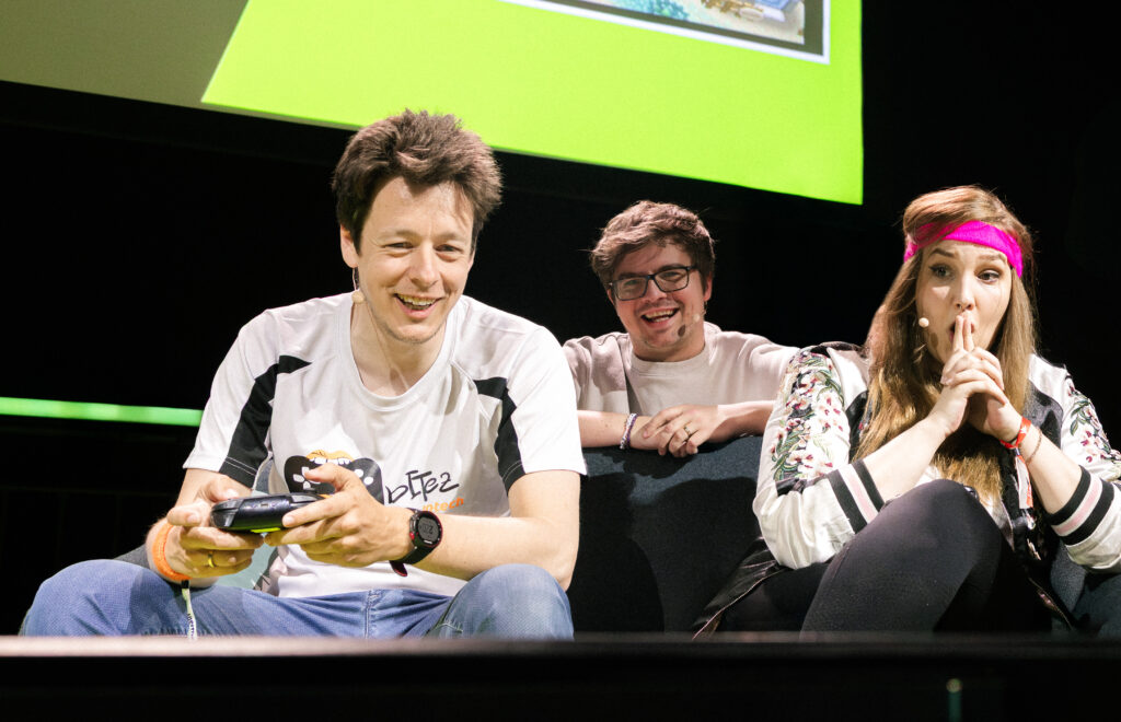 Paul Stehr zwischen zwei Teilnehmern der Gaming Olympiade der CAGGTUS