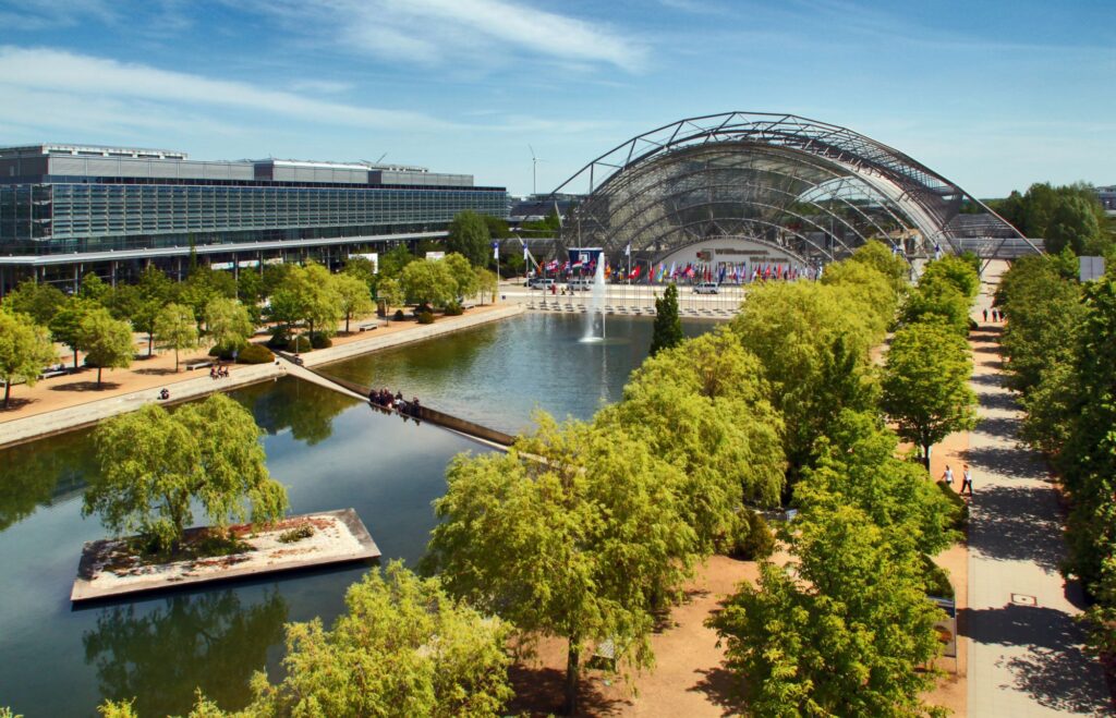 Blick auf den Messesee vor der Glashalle, mit Insel und Mosesweg